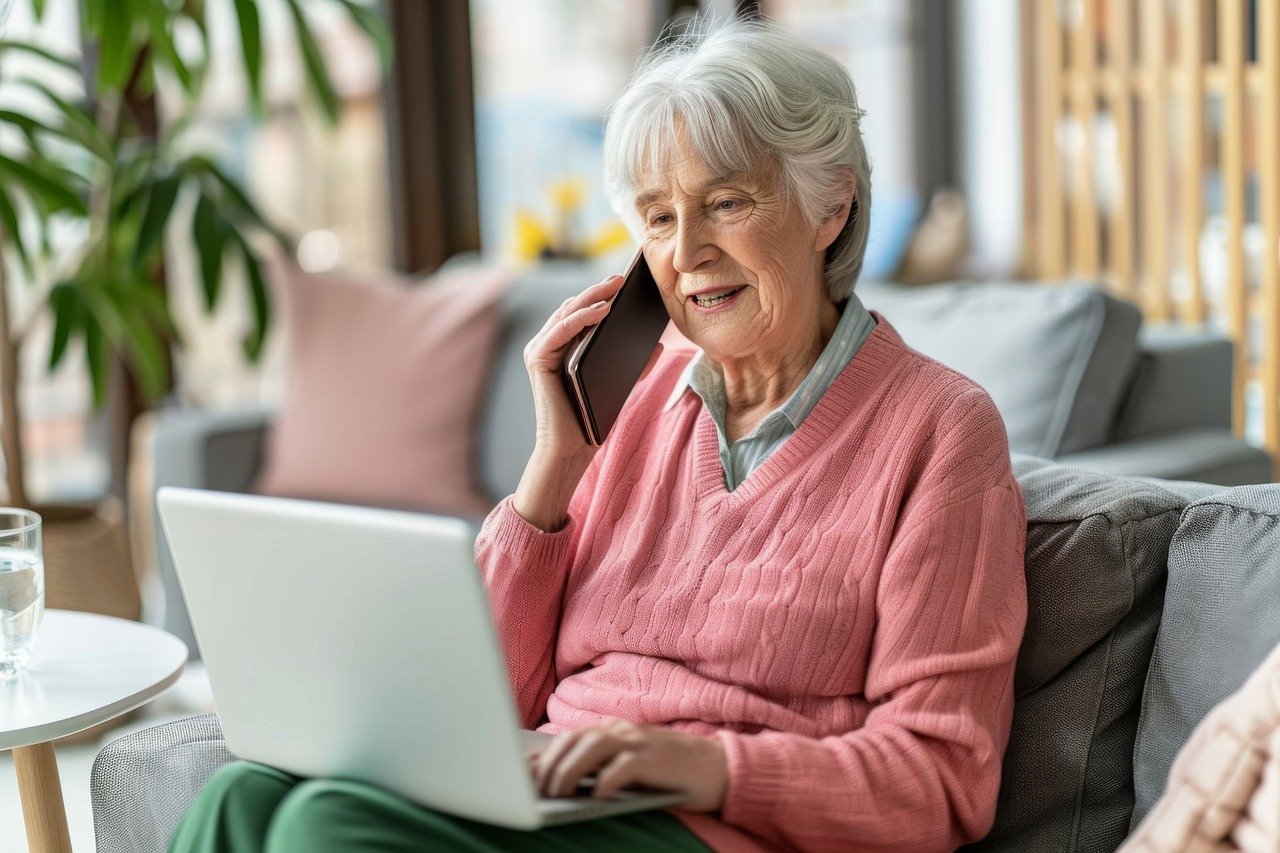 grandma looking at computer while talking on the phone
